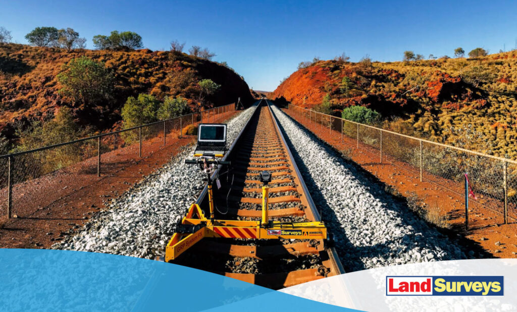 Land Surveys device on railway tracks with red earth and a blue sky